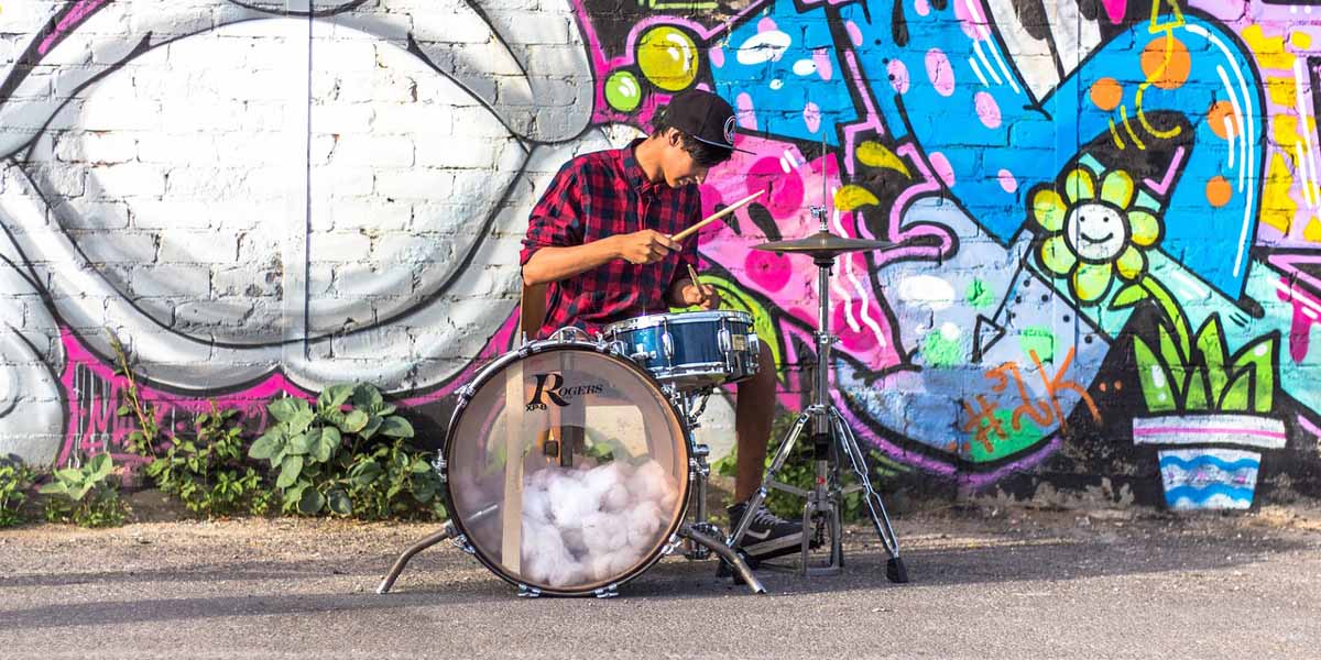 Jonge drummer op straat voor grafity muur